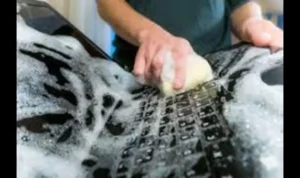 Woman scrubbing her computer with soap and a sponge