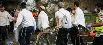 Menn carrying stretchers with people who fell in the Meron Tradgedy