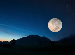Full moon at night over a mountain