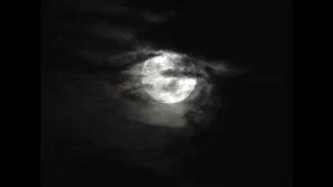 Night sky with Full moon shinning from behind clouds