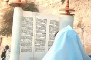 Man holding up a Sefer Torah at the Kotel