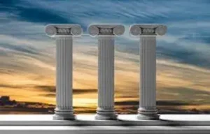 Three white greek pillars standing as sun is setting behind