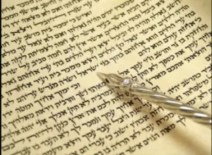 Open Torah scroll with a yad on the Torah scroll