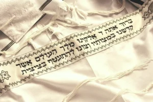 Tzitzit and a tallit with the Hebrew Bracha