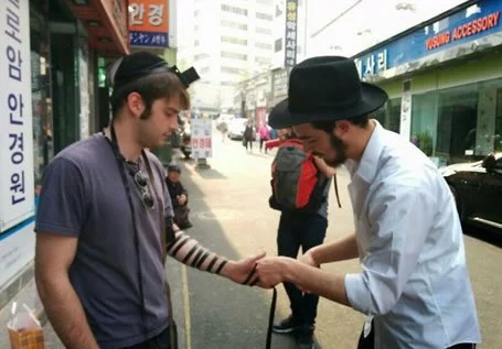 Guy putting tefillin on someone else