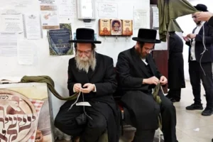 Charedi men tying Tzitzit for the army