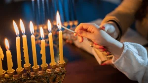 lighting the menorah, kid lighting the channukah candles