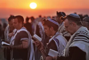 Jewish Men praying as the sun is rising outside